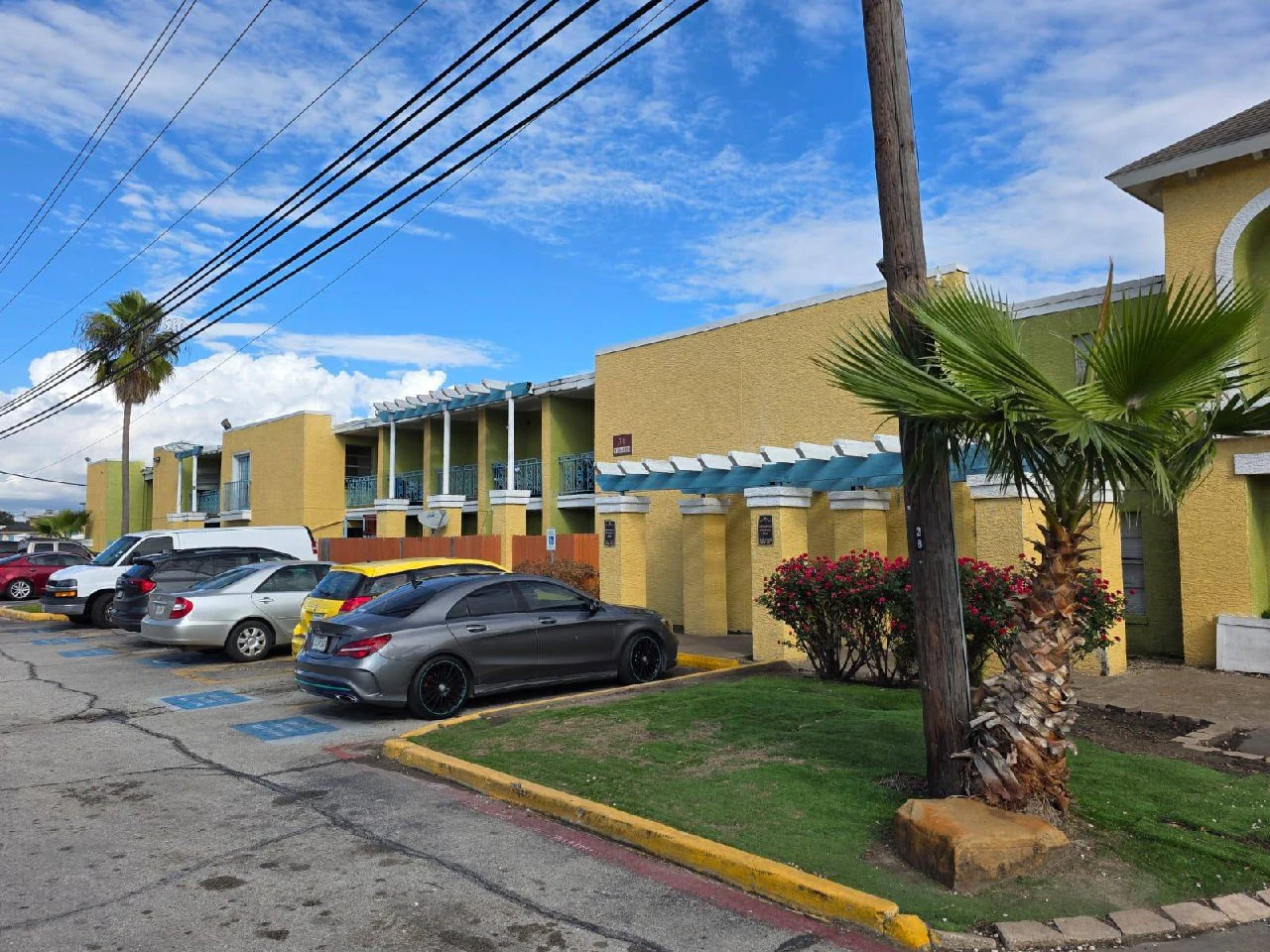 Garden-style property before — dated yellow and beige stucco